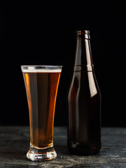 Filled with a glass of beer and a bottle on a dark wooden table