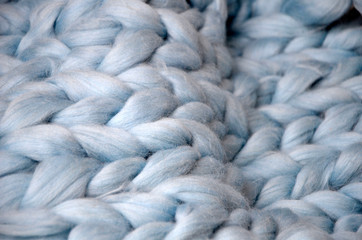 Merino wool handmade knitted large blanket, super chunky yarn, trendy concept. Close-up of knitted blanket, merino wool background