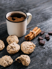 Homemade oatmeal cookies with dried fruits and nuts with coffee on wooden table