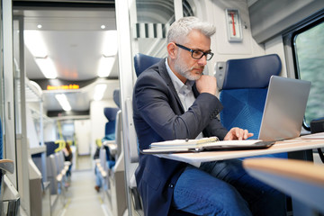 Businessman working on laptop in train