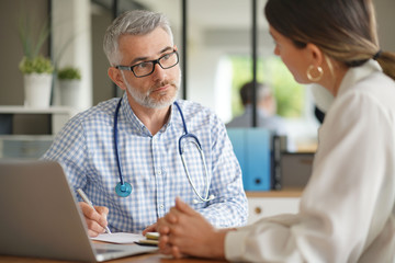 Patient having medical appointment with practitioner in doctor's office