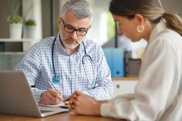 Patient having medical appointment with practitioner in doctor's office