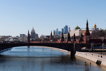 Fototapeta premium View of the Moscow Kremlin with its towers and cathedrals and reflections in the Moscow River early sunny golden morning