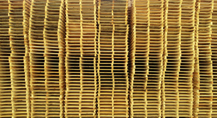 a lot of yellow pallets standing on each other in a row in several columns