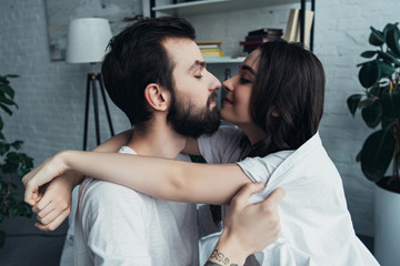 Fototapeta premium beautiful romantic young couple looking at each other and hugging at home
