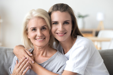 Head shot portrait of smiling old mother and young daughter