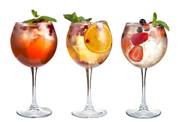 Alcohol cocktail with mint, fruits and berries on a white background. Set of cocktails in glass goblets on a long stem.