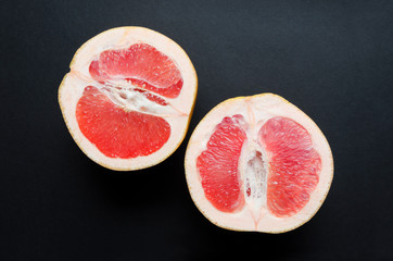 Closeup of juicy ripe grapefruit on dark surface.Constrast of colors in the nature