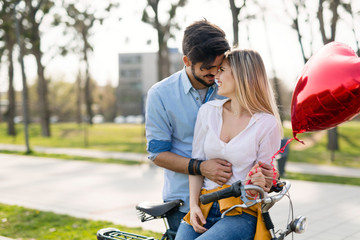 Young loving couple dating while riding bicycles in the city