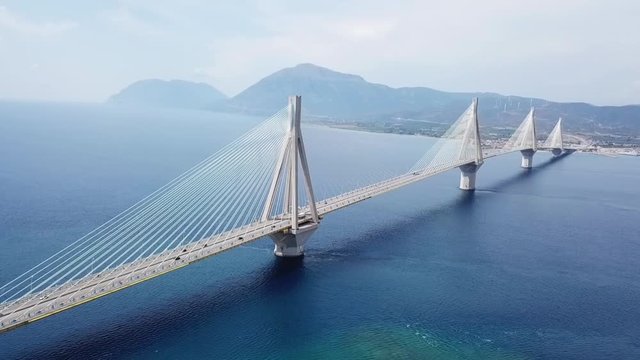 Aerial drone video of world famous cable suspension bridge of Rio - Antirio Harilaos Trikoupis, crossing Corinthian Gulf, mainland Greece to Peloponnese, Patras