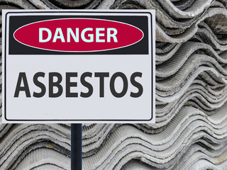 sign danger asbestos and a stack of sheets roof of asbestos.