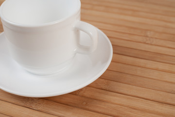 White cup mock-up inclined of wooden table