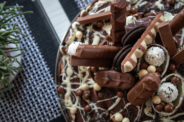 Fototapeta na wymiar Beautiful homemade cake with chocolate, chocolate cookies and candies