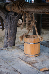 Naklejka premium Wooden bucket standing on the cover of groundwater well