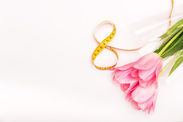 greeting card or background for the holiday of March 8 with flowers and centimeter tape