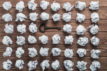 Concept of success and opportunity with old key among paperballs