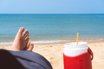 man drinking cocktail on the beach