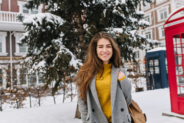 Portrait joyful smiling young woman walking on street in city, cold winter weather. Fashionable...