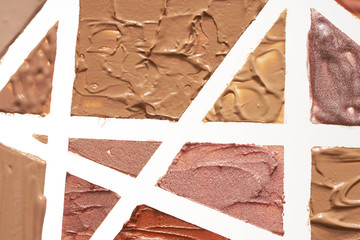 Texture of multi-colored strokes of various make-up cosmetics on a white