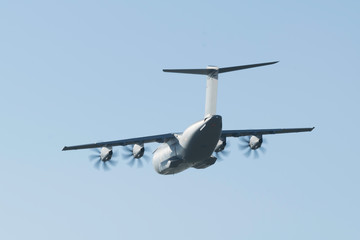 Avion de transport militaire Airbus A400M de démonstration en vol en vue arrière sur un fond de ciel bleu au dessus de St Nazaire
