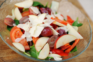 Multicomponent vegetable hearty salad in a bowl on a wooden board