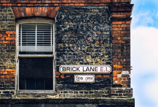 Brick lane vinrage street sign with house window and red brick wall