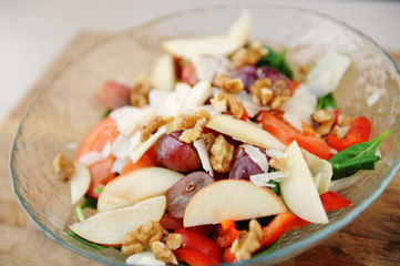 Multicomponent vegetable hearty salad in a bowl on a wooden board