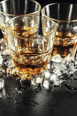 Whiskey and ice on rustic wood background