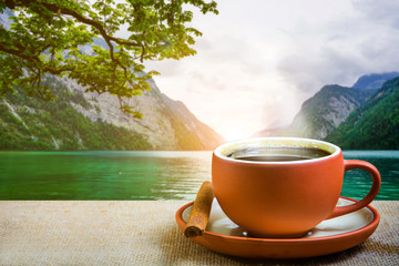 Espresso on the table with blur landscape of lake and mountain