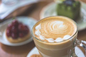 Cup of Latte on the table in coffee shop background