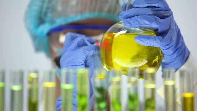 Biologist marking flask with biofuel alternative fuel research nature protection