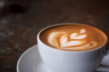Cup of Latte on the table in coffee shop background