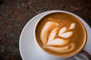 Cup of Latte on the table in coffee shop background