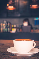 Cup of Latte on the table in coffee shop background