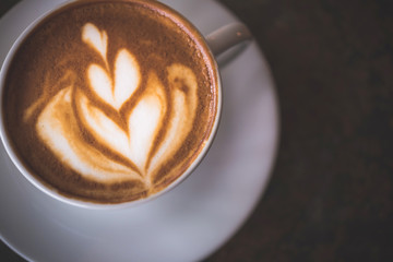 Cup of Latte on the table in coffee shop background