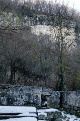View of  foundation at ancient building, stone wall and door toward cliff in Demir Baba Teke, cult monument honored by both Christians and Muslims in winter near Sveshtari village, Municipality Isperi