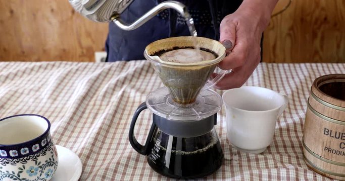Barista pouring water on ground coffee in kono dripper : Hand Drip Coffee, Kono drip