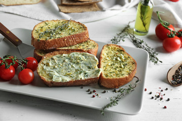 Tasty cut garlic bread on plate