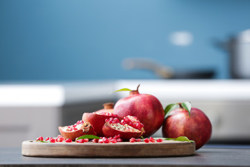 Board with ripe pomegranates on kitchen table