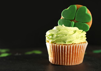 Tasty cupcake and clover on table. Saint Patrick's Day celebration