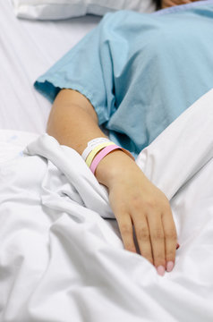 A image of a patients hand lying in a hospital bed