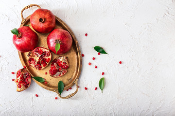 Metal tray with ripe pomegranates on white background