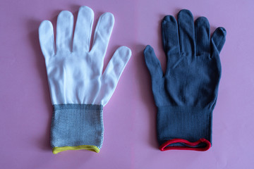 white and black work gloves on pink background. overalls and uniforms. hand protection