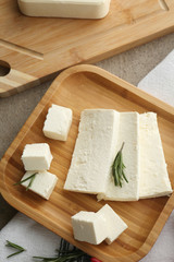 Plate with tasty feta cheese on table