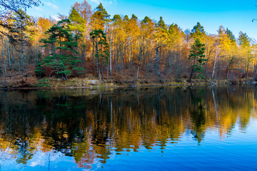 Fototapeta premium Magic colorful forest reflecting in silent lake water in autumn season