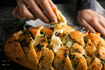 Woman eating tasty garlic bread, closeup