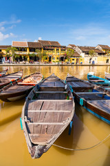 Fototapeta na wymiar Boats tied on the dock along the riverbank of the Thu Bon River in the Old Quarter of Hoi An (Hội An), Vietnam. Hoi An is a popular tourist destination in central Vietnam.