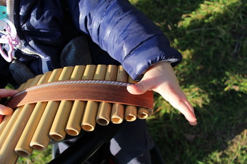 enfant jouant de la flute de pan