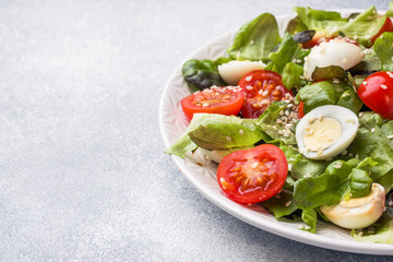 Fresh salad with tomatoes and quail eggs and lettuce. Copy space