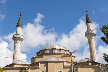 Fototapeta na wymiar the dome of the mosque and two minarets against the blue sky with clouds, the religion